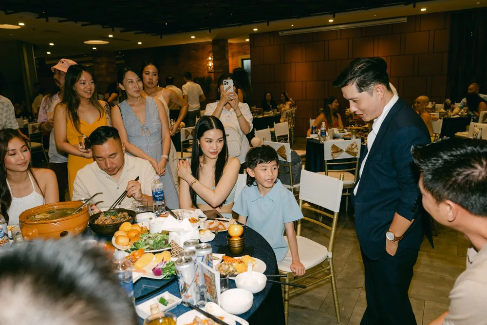 Randy Huynh performing close-up magic between tables at a wedding reception in Da Nang