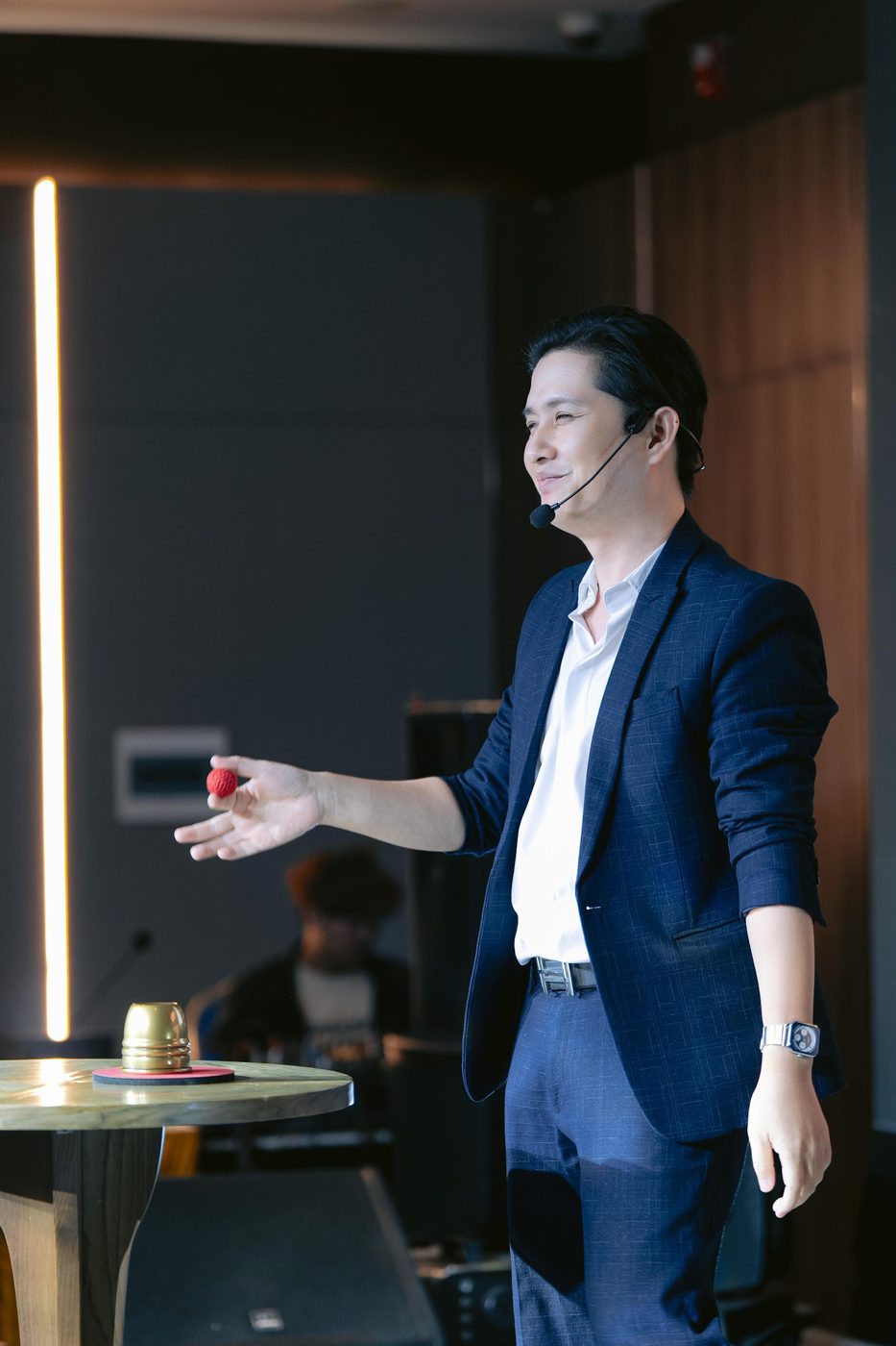 Randy Huynh performing close-up magic with a red ball at an event in Da Nang